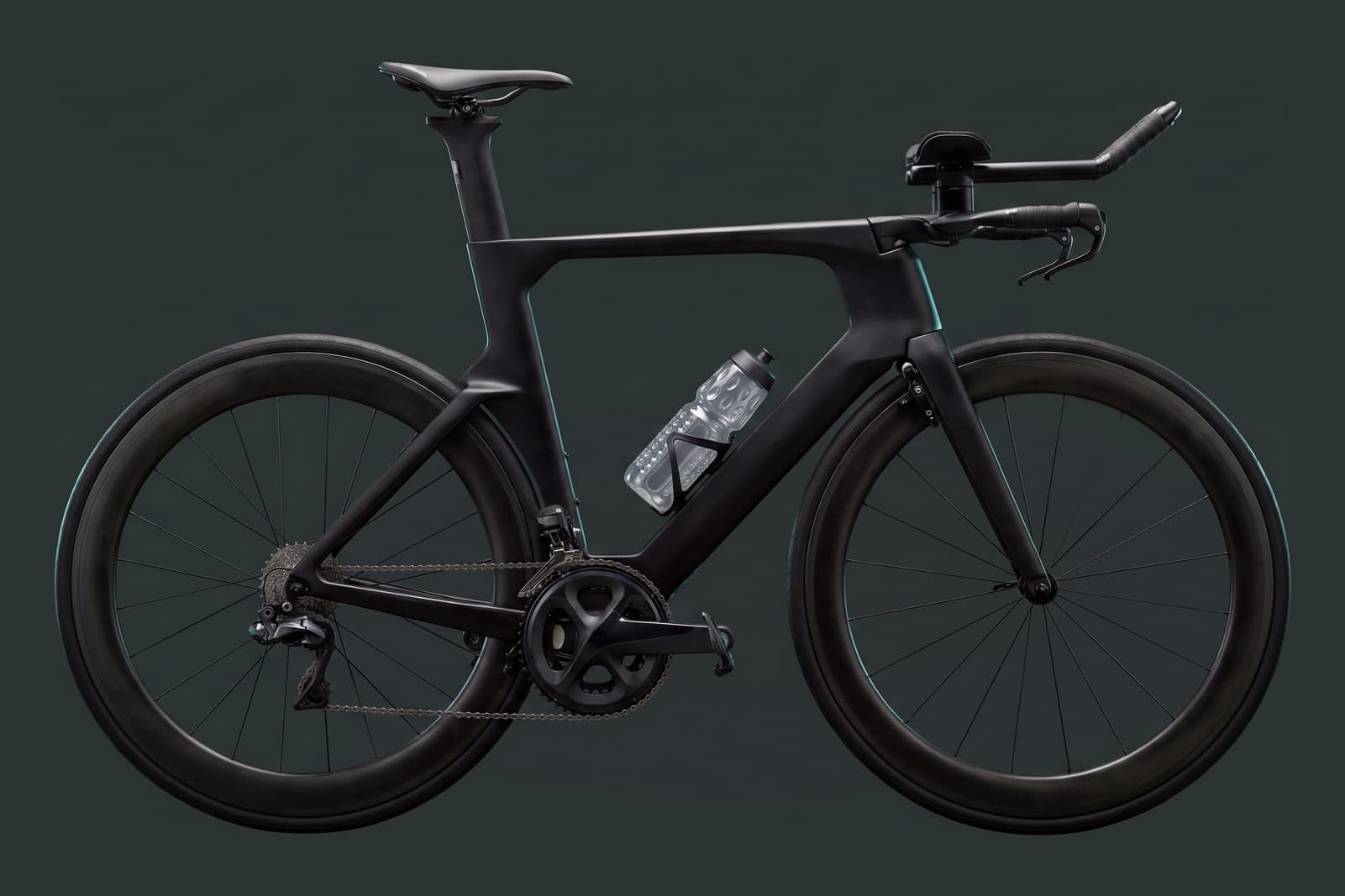 A time trial bicycle in profile, carrying the transparent, dimpled Ottr Bottle in a standard cage on its down tube.